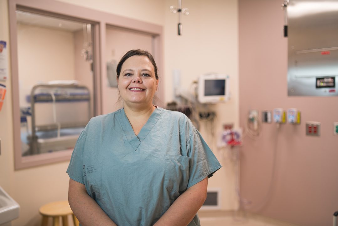 Gillyan Gravelle, registered nurse at Health Sciences North in Sudbury, Ontario, stands in a clinical room in the surgical area, wearing scrubs.